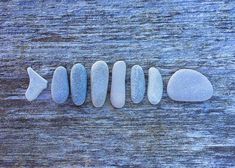 five stones arranged in a row on a wooden surface