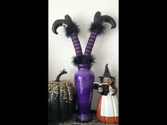 two halloween decorations are sitting on a shelf next to a vase with fake witches in it