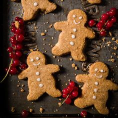 several gingerbread cookies with white chocolate and cherries on a baking sheet, ready to be eaten