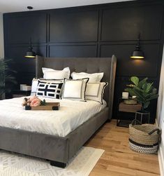 a bedroom with black walls, white bedding and wooden floors is pictured in this image