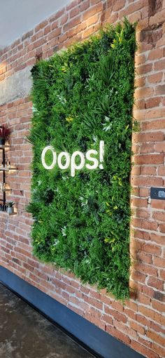 Faux plants green wall panel with LED logo Brick Wall Office, Faux Green Wall, Fake Plant Wall, Green Wall Panel, Office Reception Design, Home Studio Ideas, Artificial Green Wall, Smoothie Shop, Artificial Plant Wall