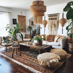 a living room filled with lots of furniture and plants on top of a wooden floor