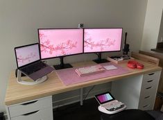 two computer monitors sitting on top of a desk next to a keyboard and mouse pad