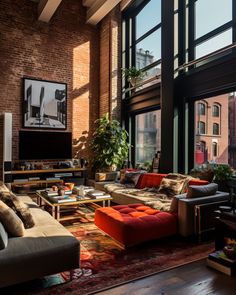 a living room filled with lots of furniture next to large windows on top of a brick wall