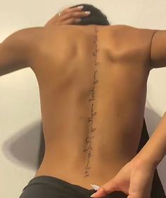 the back of a woman's body with writing on her lower back and upper part