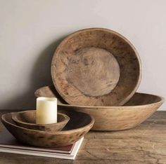 two wooden bowls and a candle on a table