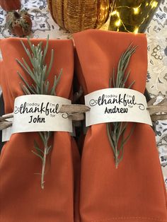 two napkins tied to each other with rosemary on them