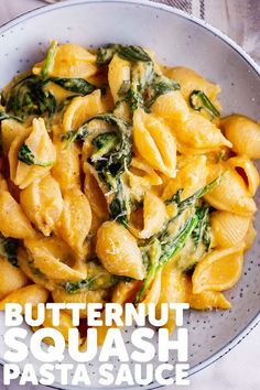 a white bowl filled with pasta and spinach