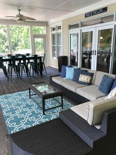 a living room filled with furniture on top of a hard wood flooring covered patio