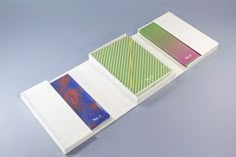 an open box containing three different colored papers