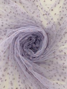 an image of a white and grey scarf with hearts on it's center piece