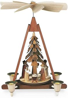 a christmas tree made out of wood with candles on the bottom and an angel above it