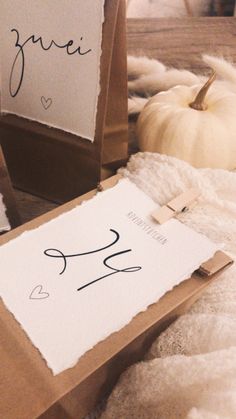 a couple of boxes sitting on top of a bed covered in white blankets and pumpkins