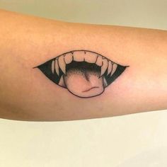 a close up of a person's arm with an open mouth tattoo on it