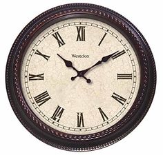 a wall clock with roman numerals on the face and numbers in different colors