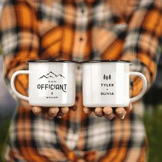 two white coffee mugs with the words official and tyler written on them are held in front of a man's chest