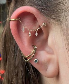 a woman wearing three different ear piercings