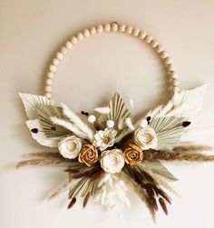 a necklace with flowers and feathers hanging on the wall