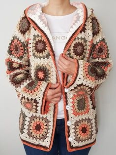 a woman is wearing a crocheted jacket with an orange hoodie and white t - shirt