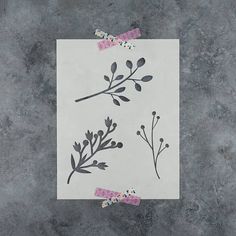 a piece of paper with flowers and leaves on it sitting on top of a table