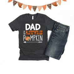 Dad of the little Pumpkin birthday shirt! We love this orange plaid print paired with the super cute patch print pumpkin - so cute for a fall theme birthday! We do have a matching one for Mom and the Birthday child in our shop. Every tee is handmade to order with love. Printed on our Unisex Adult Tees, these do run large. For a women's fit, we do suggest sizing down. For a looser fit, size as you would normally purchase. Please note since all tees are handmade, graphic placement may vary slightl Cute Father's Day Shirt With Crew Neck, Cute Crew Neck Shirt For Father's Day, Birthday Cotton Shirt With Funny Print, Funny Print Cotton Top For Father's Day, Fun Cotton Shirt For Birthday, Fun Cotton Birthday Shirt, Cute Cotton Shirt For Father's Day, Cute Fall Birthday Tops, Cotton Graphic Print Shirt For Birthday