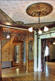 the inside of a house with wood flooring and ornate decorations on the walls, windows, and ceiling