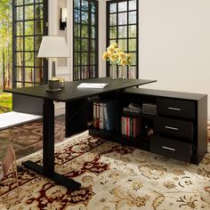 a black desk sitting in front of a window next to a lamp and book shelf