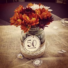 a vase filled with lots of flowers on top of a table next to some tags