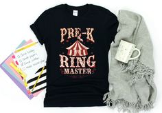 a black shirt with the words prek ring master on it next to some papers