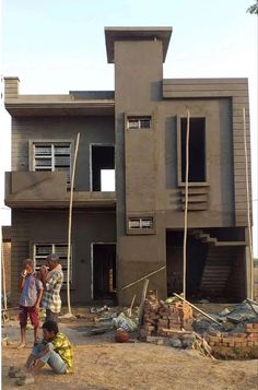 three men are standing in front of a house under construction