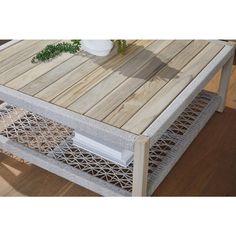 a coffee table made out of wood and wicker with a plant in the middle