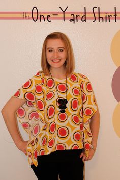 a woman standing in front of a wall with her hands on her hips