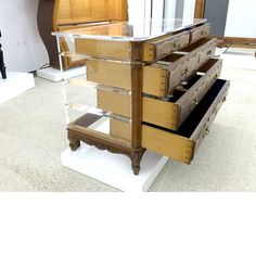 a wooden dresser with drawers and glass top on display in a store or showroom