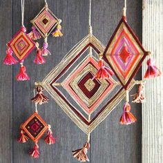 some tassels hanging from a wooden wall with red and pink decorations on it