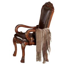 an ornate wooden chair with brown leather upholstered seat