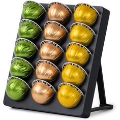 an assortment of colored chocolates in a tray on a black stand with white background