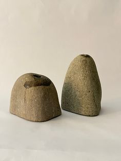 two rocks sitting next to each other on a white surface