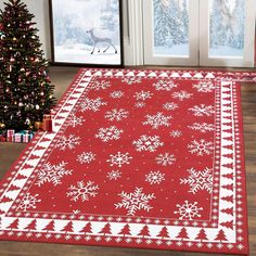 a red rug with white snowflakes on it in front of a christmas tree