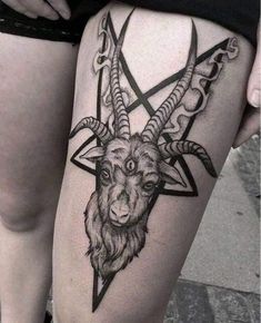 a goat head tattoo on the thigh, with two horns and an inverted star in the middle