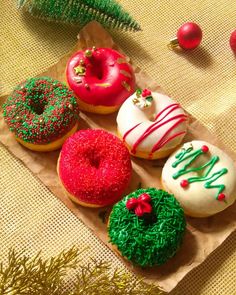 there are many different types of donuts on the table with christmas decorations around them