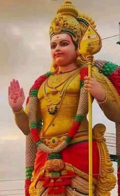 a large statue of a hindu god holding a staff