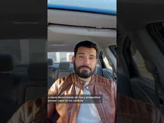 a man with a beard sitting in a car