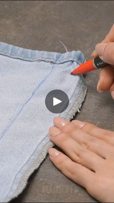 someone is using a pencil to draw on the side of a pair of jeans