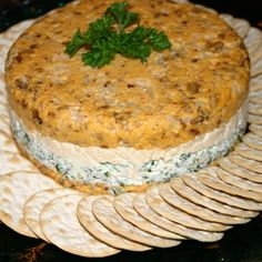 there is a cake on the plate with crackers around it and garnished with parsley