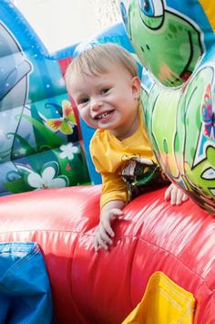 a little boy sitting on top of a bouncy house