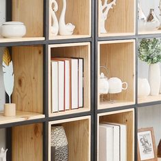 several wooden shelves with books and vases on them