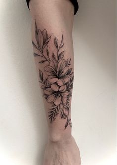 a woman's foot with a flower tattoo on the left side of her leg