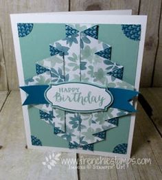 a happy birthday card with blue and white flowers on the front, and a ribbon at the bottom