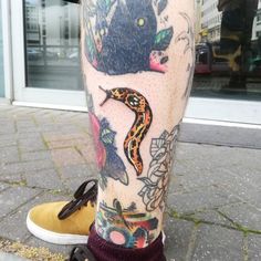 a person with tattoos on their legs and feet is standing in front of a building