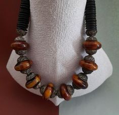 An opulent long necklace with vintage marbled brown-yellow bakelite beads.Art deco-ca:1930.Silver plated metal beads are handmade in Marocco.Black bakelite -heishi are made for trade in Nigeria. Size of bakelite beads : 19 mm x 30 mm Length : 80 cm or 31,49 inch Weight : 215 gram Antique Brown Jewelry With Large Beads, Brown Bakelite Jewelry As A Gift, Vintage Long Beaded Necklaces, Hand-strung, Vintage Brown Necklaces With Polished Beads, Vintage Adjustable Hand-strung Beaded Necklaces, Brown Bakelite Jewelry Gift, Luxury Vintage Orange Beads, Vintage Hand-strung Orange Beaded Necklace, Bakelite Necklace